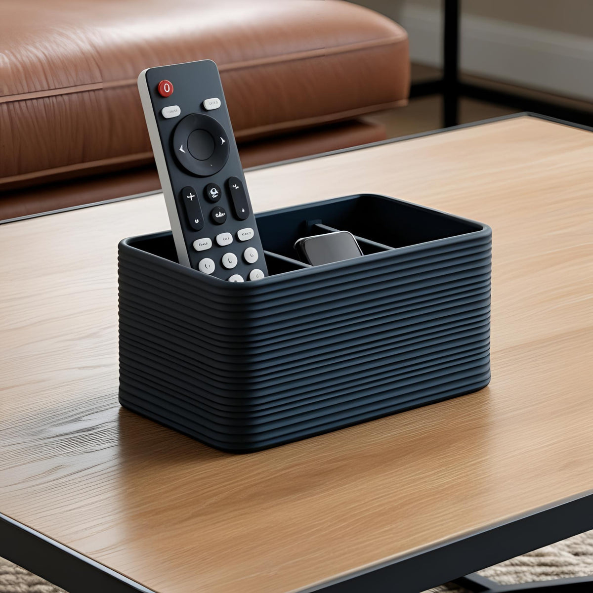 Black ribbed remote control holder with three compartments holding a remote on a wooden coffee table