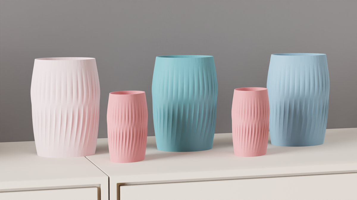 A collection of Ripplied Barrel Vases displayed against a soft grey wall