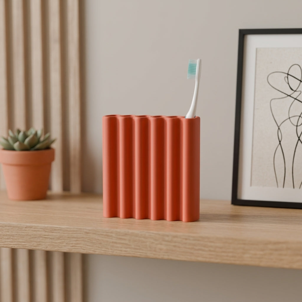 Terracotta orange ripple toothbrush holder on dark oak cabinet with small vase and towel lifestyle