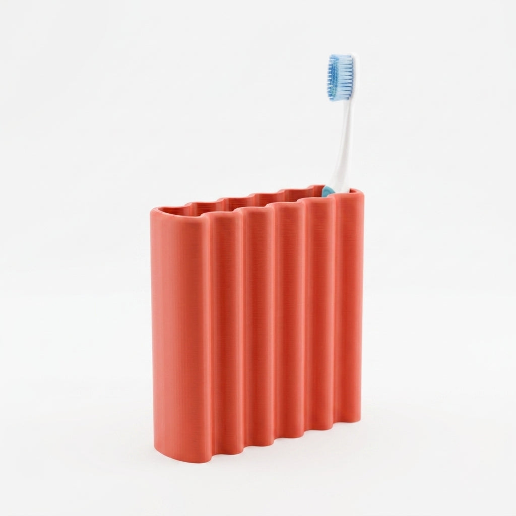 Grey ripple toothbrush holder held in hand showing wavy tube structure close up
