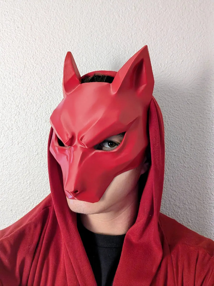 Red Kitsune Wolf Mask held in profile showing the black strap